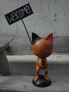 welcomeプレートを持った木彫りのネコ