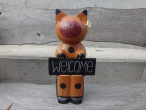 welcomeプレートを持った木彫りのネコ