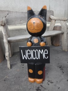 welcomeプレートを持った木彫りのネコ